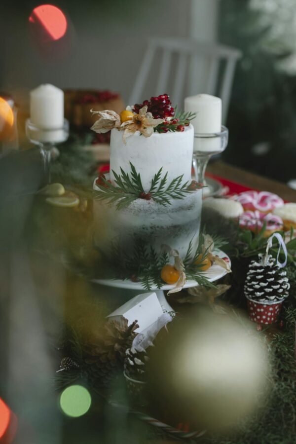 Christmas cake on table decorated with leaves and berries